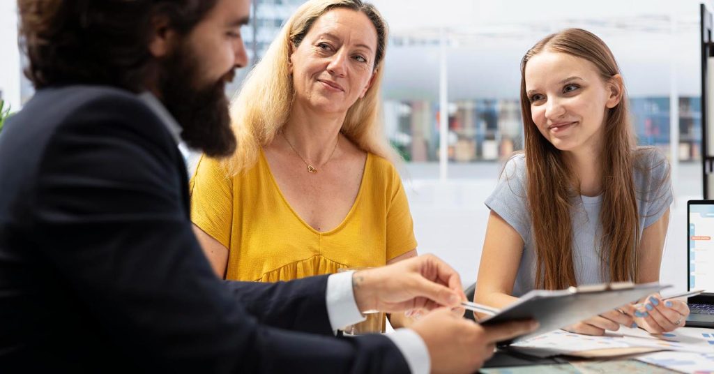 Financial advisor showing different personal loan options to a family at an office desk