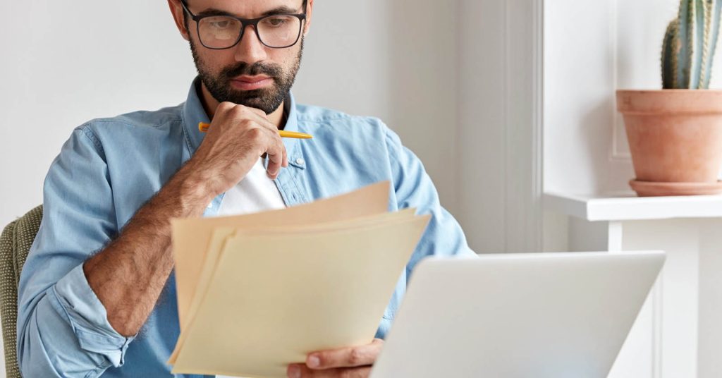 Person reviewing an insurance policy on a laptop at home