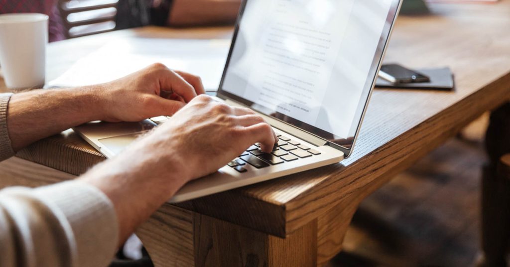Entrepreneur preparing outreach list for first customers on a laptop