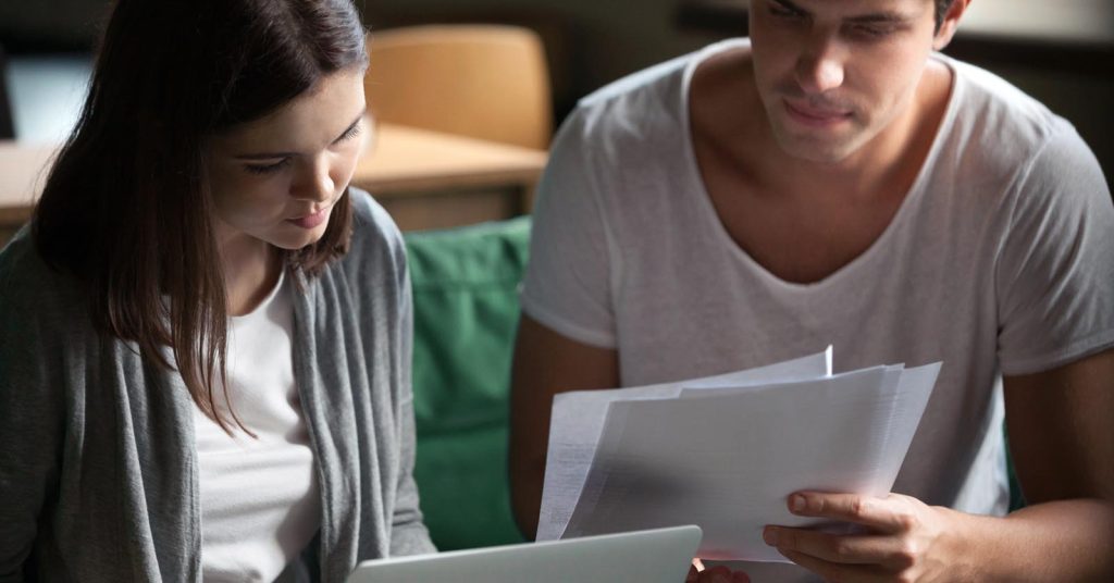 Couple reviewing bills and payment records on a laptop