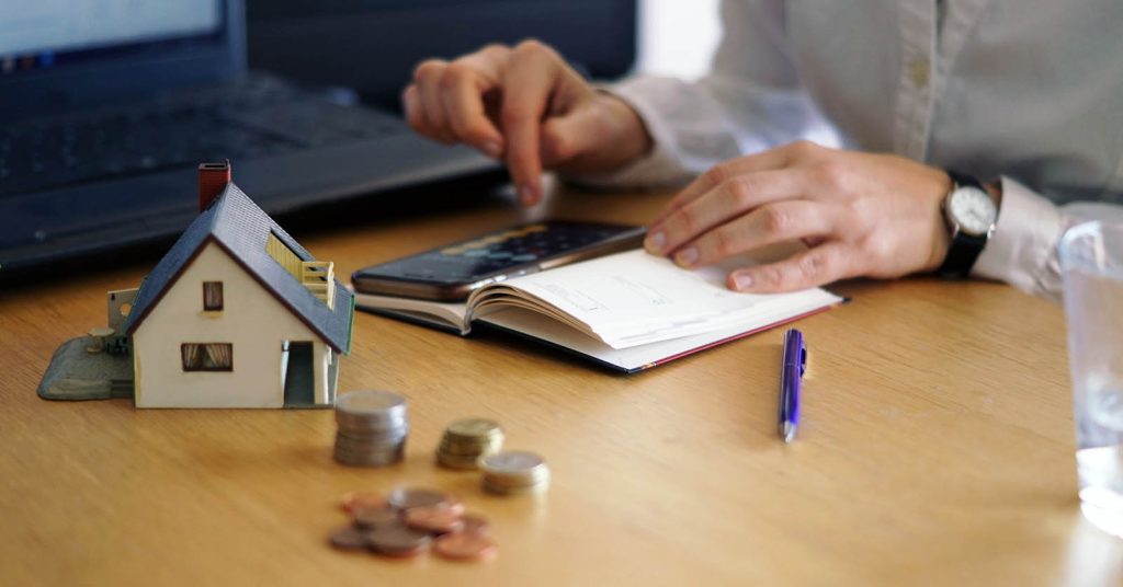 Person calculating homebuying costs and housing budget in an office