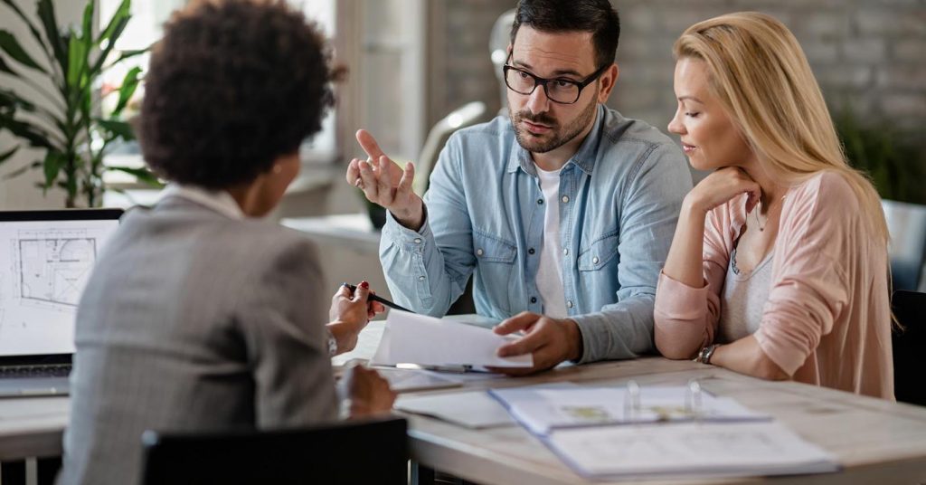 Couple reviewing mortgage documents with a financial advisor