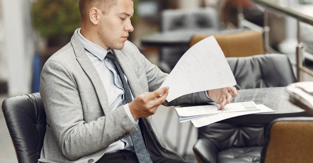 Man reviewing personal loan documents and fees before signing