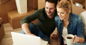Couple reviewing credit and mortgage information on a laptop before buying a home
