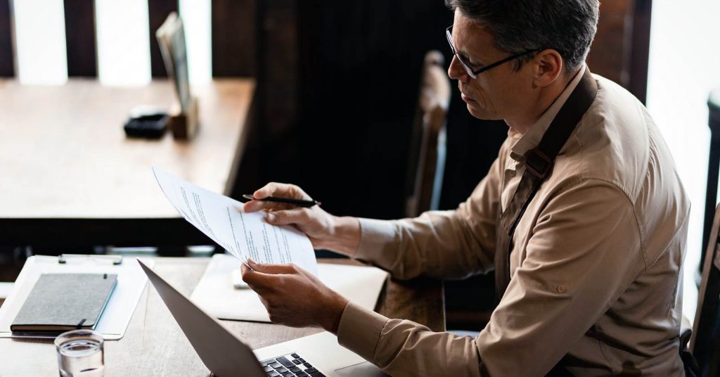 Man reviewing credit and financial documents before applying for a personal loan