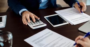 Financial consultant reviewing mortgage escrow paperwork with a client