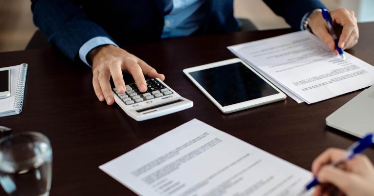 Financial consultant reviewing mortgage escrow paperwork with a client
