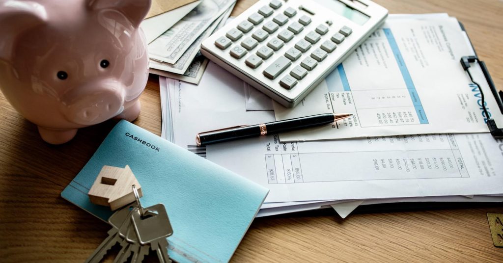 Real estate paperwork and house model for estimating cash to close