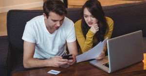 Couple reviewing mortgage documents and housing costs at home