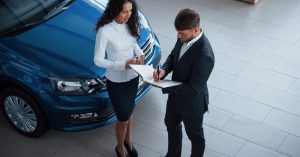 Man reviewing car financing paperwork before signing an auto loan agreement