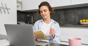 Woman reviewing student loan notes and interest rate information at home