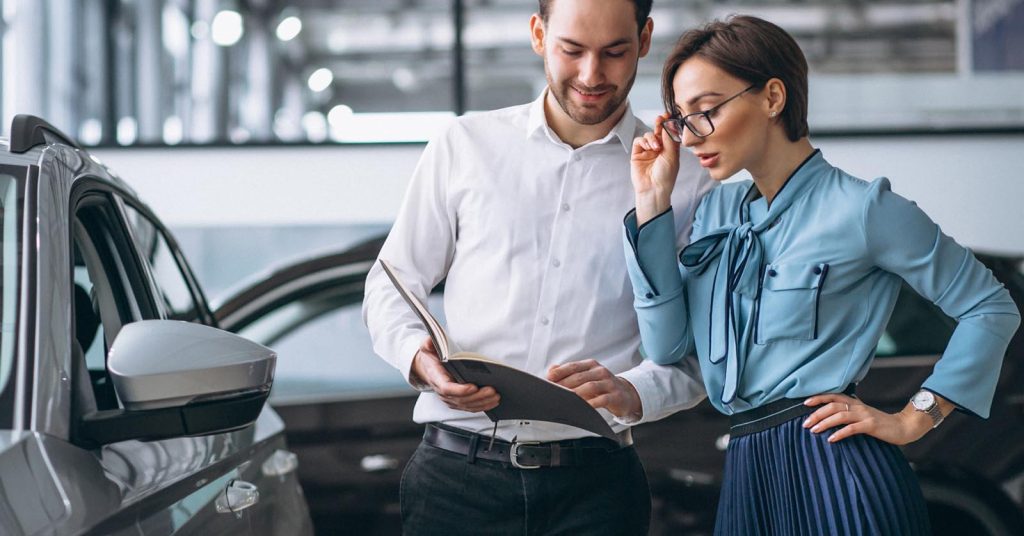 Woman choosing a car in a showroom during an auto loan preapproval window