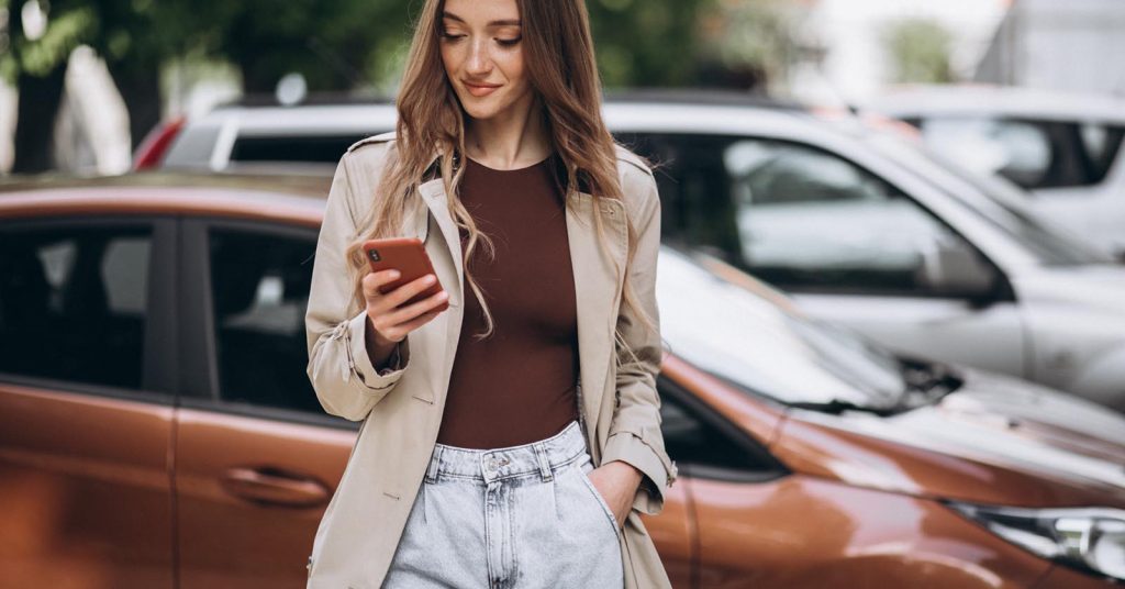 Woman using her phone while comparing car loan applications online