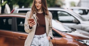 Woman using her phone while comparing car loan applications online