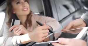 Buyer reviewing car purchase paperwork and down payment details before signing
