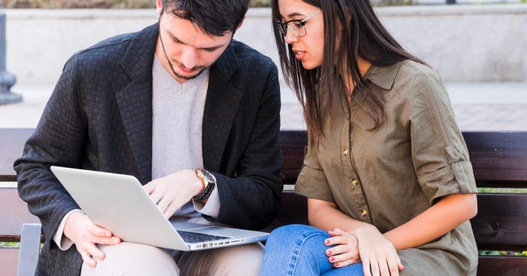 Couple reviewing student loan consolidation options and monthly payments on a laptop