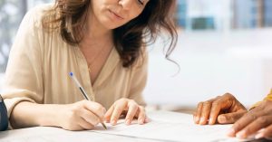 Borrower reviewing and signing student loan cosigner release paperwork