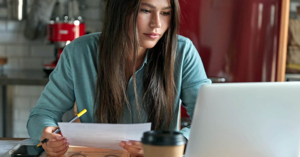 Student reviewing loan paperwork and repayment options on a laptop at home