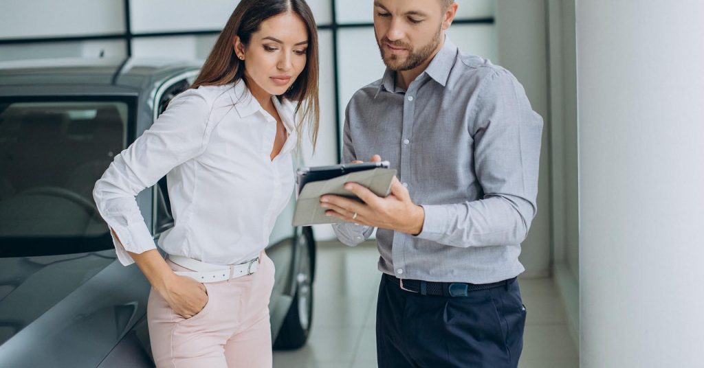 Woman reviewing car purchase paperwork before deciding whether the monthly payment is affordable
