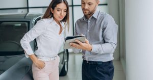 Woman reviewing car purchase paperwork before deciding whether the monthly payment is affordable
