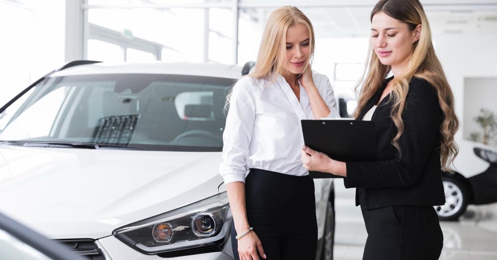 Woman reviewing car refinance paperwork on a clipboard before taking cash out from vehicle equity