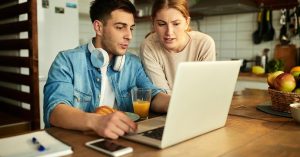 Couple reviewing a frozen bank account and debt levy notice on a laptop