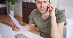 Man calling for help while reviewing default judgment debt paperwork