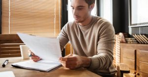 Man reviewing hospital financial assistance paperwork at home