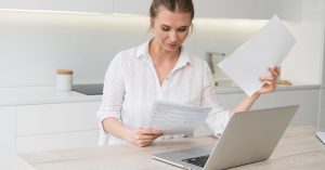 Woman reviewing income and benefit documents to check what money is protected from debt collectors
