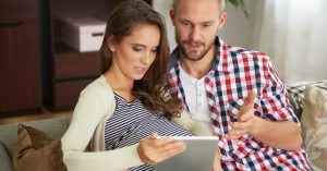 Couple reviewing an unexpected financial message from a debt collector on a tablet