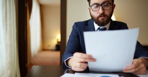 Man reviewing credit card statements to decide whether his debt is becoming unmanageable