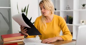 Woman reviewing auto loan documents before deciding how bankruptcy will affect her car