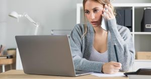 Woman reviewing a budget during a phone call about debt repayment