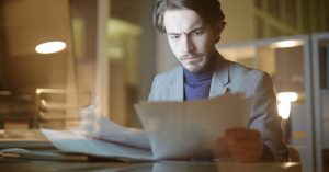 Man reviewing financial documents related to credit card debt after a family member's death