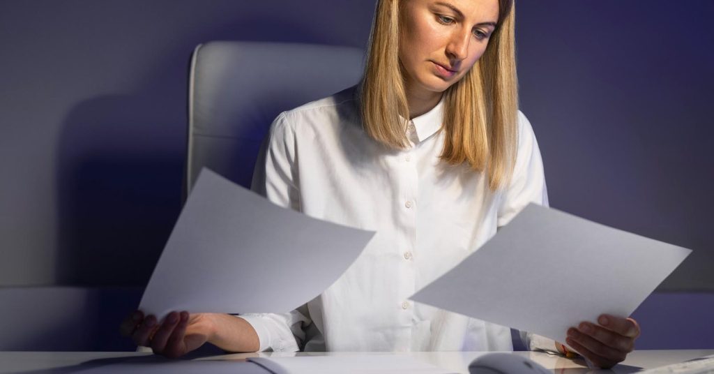 Woman comparing credit card statements to understand why her balance keeps growing