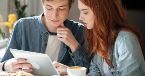 Young couple looking at a tablet together at a table