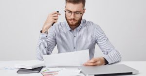 Business owner reviewing licensing and permit documents at a desk