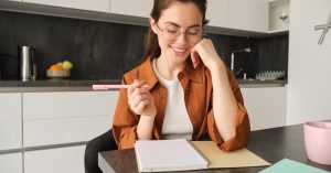Woman writing notes at a kitchen table