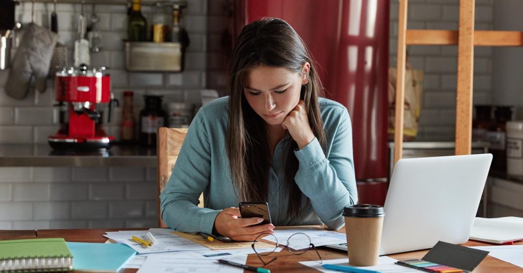 Woman reviewing credit card accounts and payment records after debt consolidation