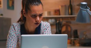 Woman reviewing a suspicious debt consolidation offer on her laptop