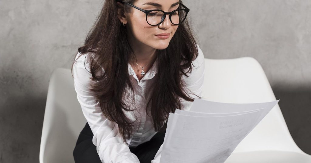 Woman reviewing a written debt settlement agreement before making payment