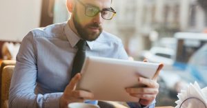 Man in business attire reviewing information on a tablet