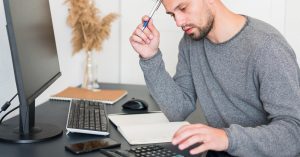 Man reviewing debt payoff calculations and credit information on a computer