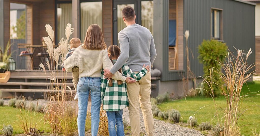 Family standing together in front of a house