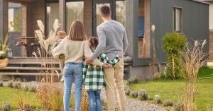 Family standing together in front of a house