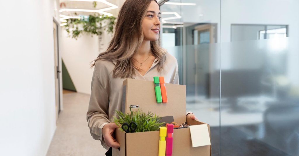 Employee leaving the office with a box after resigning from a job