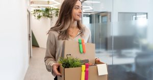 Employee leaving the office with a box after resigning from a job