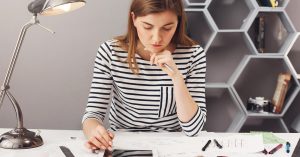 Woman comparing home equity loan and HELOC terms while reviewing household finances