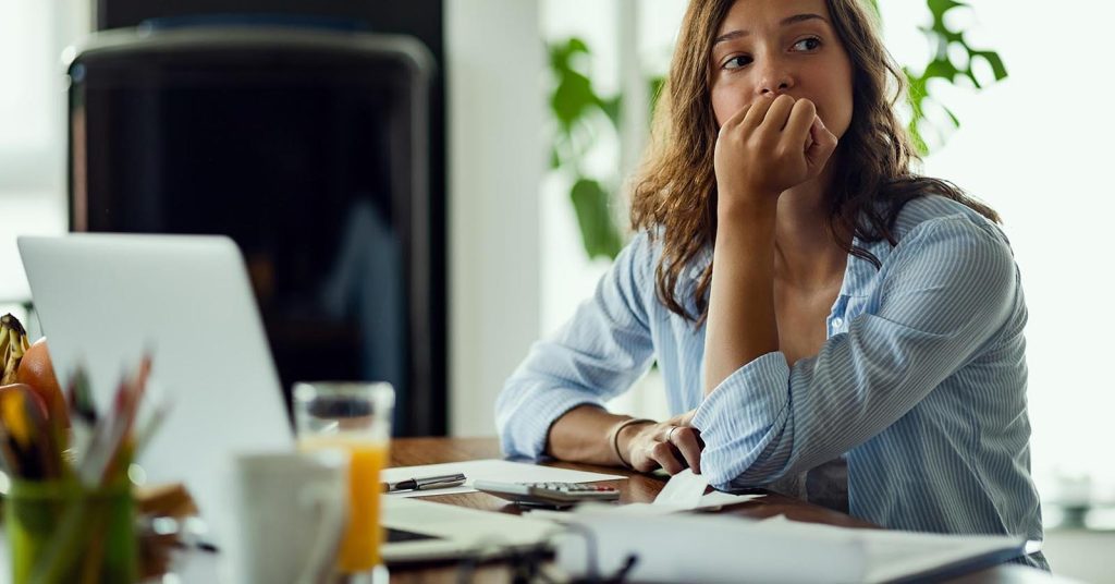 Woman looking concerned while reviewing documents at a table