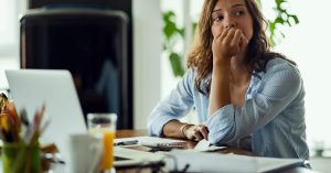 Woman looking concerned while reviewing documents at a table